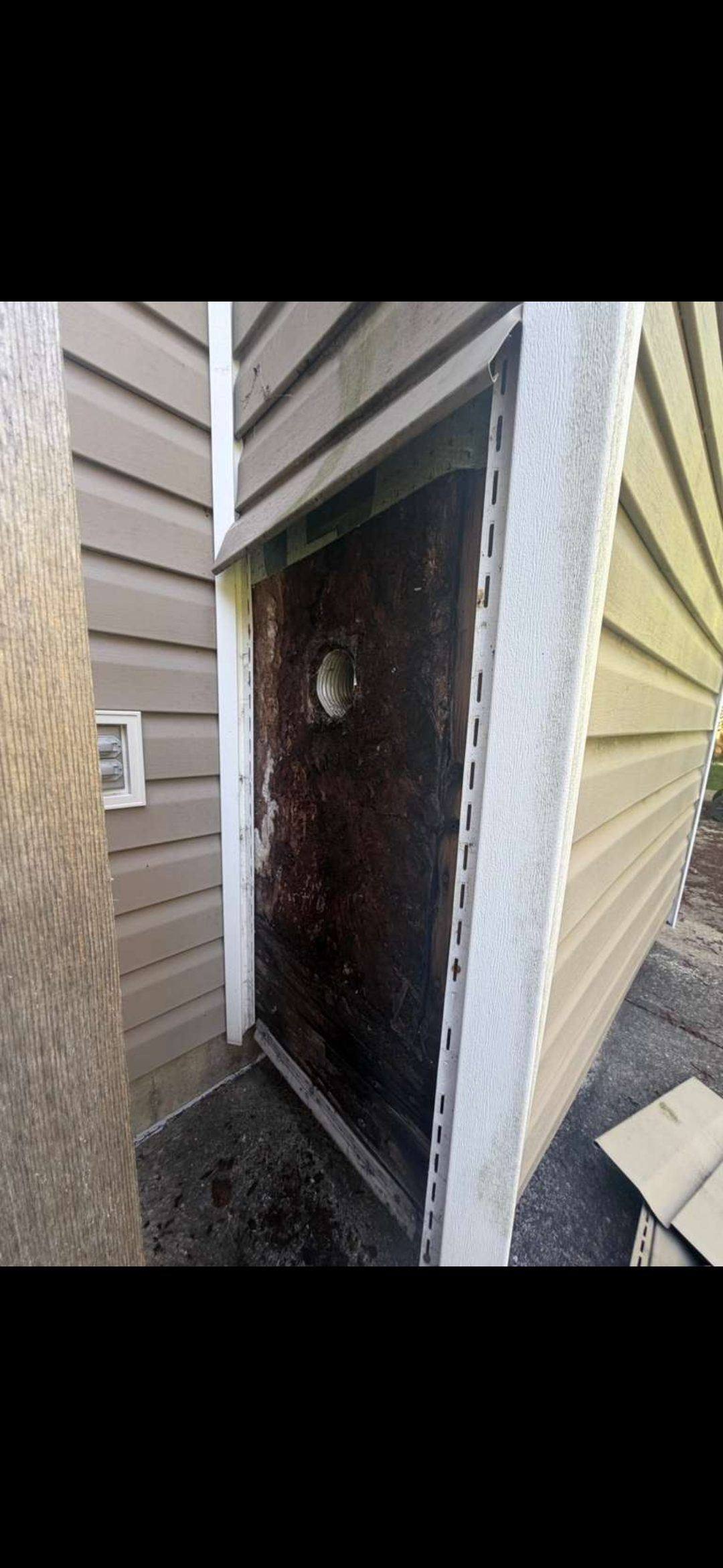 Water damage and destroyed house wrap inside a chimney chase wall