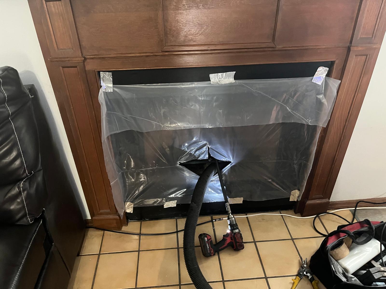 Chimney sweep in progress — sealed fireplace with HEPA vacuum