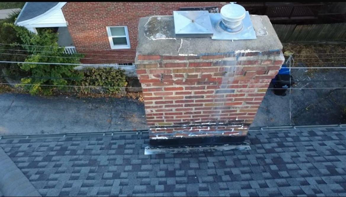 Wide chimney with no cricket — water pooling behind chimney