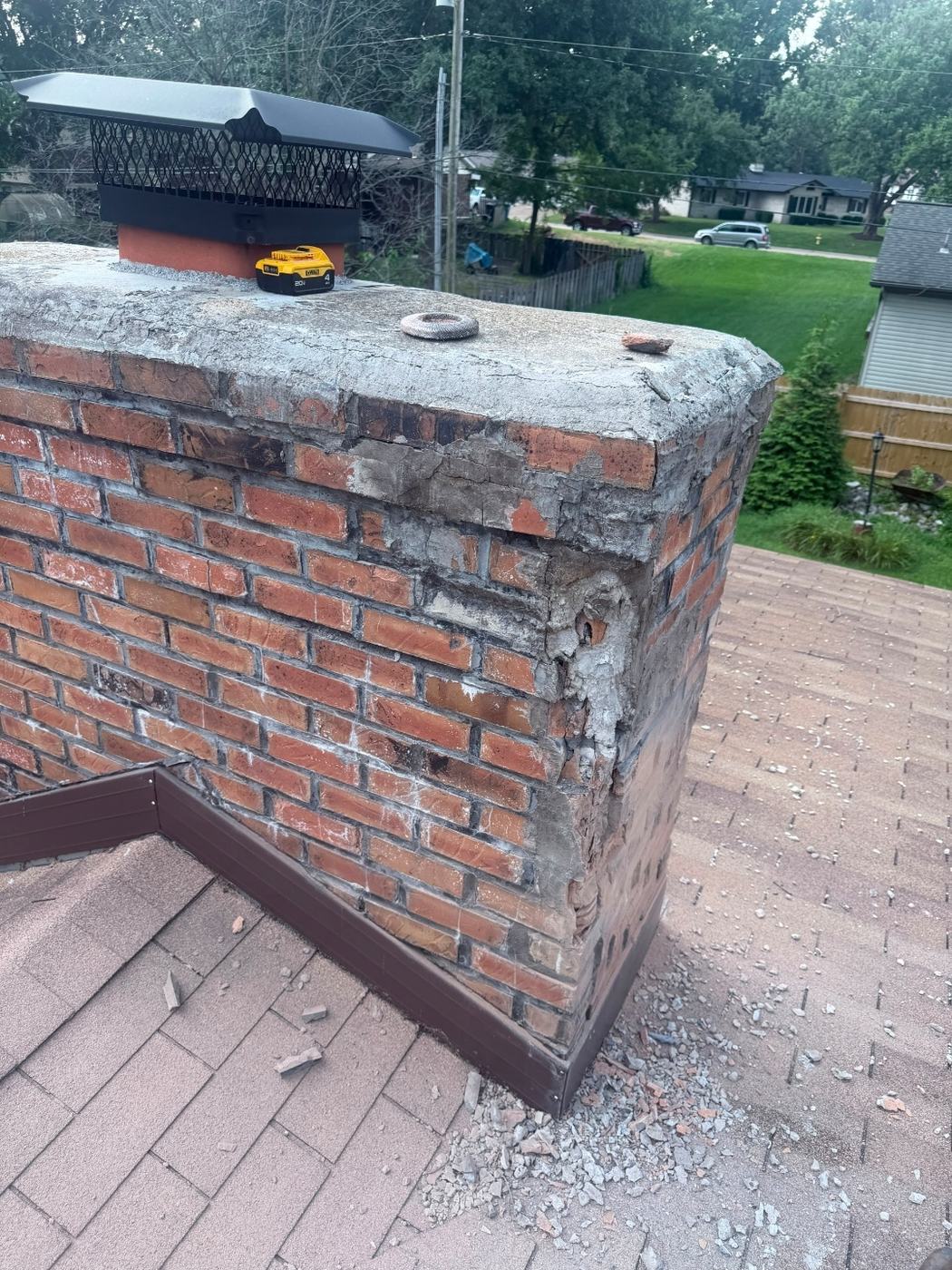 Cracked chimney crown with open mortar joints and patch material breaking away along the corner, St. Louis MO