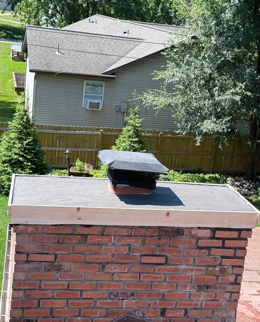 Freshly poured chimney crown with an overhang that throws water clear of the brick instead of letting it run down the face