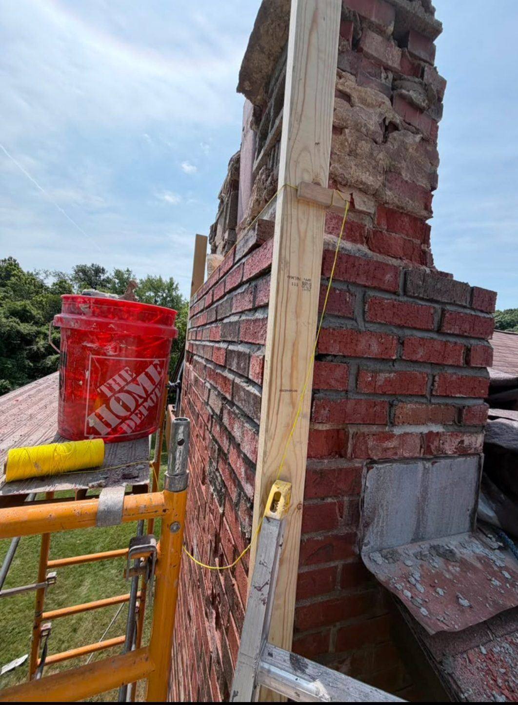 Rebuilding the chimney course by course with new brick