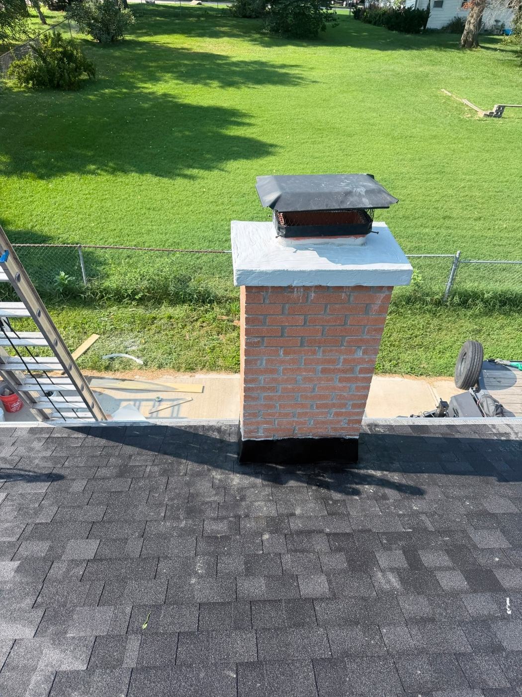 Chimney rebuilt from the roofline up with new brick, new top flue tile, poured crown with an overhang and a new cap, St. Louis MO