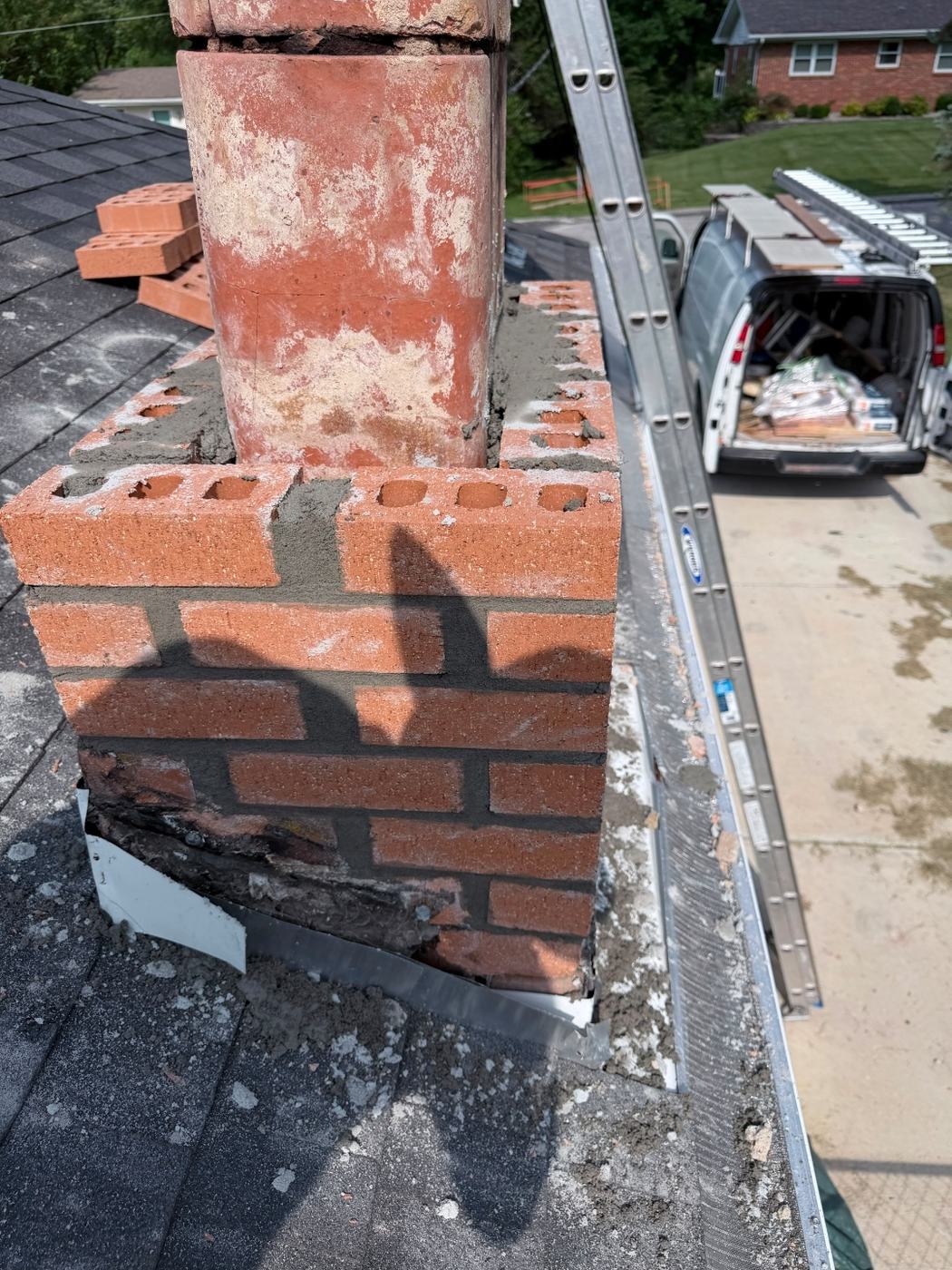 First courses of new chimney brick going back down at the roofline with new flashing tucked in as the brick comes up