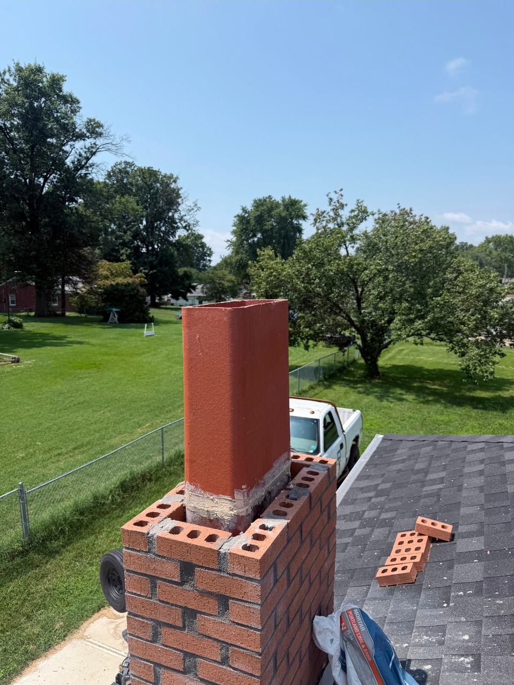 Cracked top clay flue tile replaced with a new tile and brick built up around it during a chimney rebuild