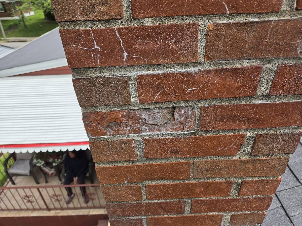 Close-up of open mortar joints and efflorescence on a University City chimney